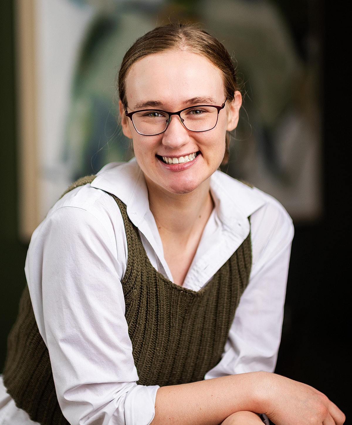 Smiling woman in casual, stylish clothing.