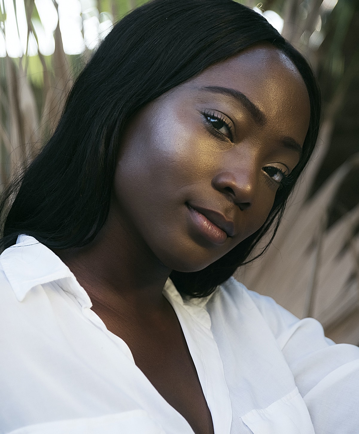 Woman in a white shirt with natural background.
