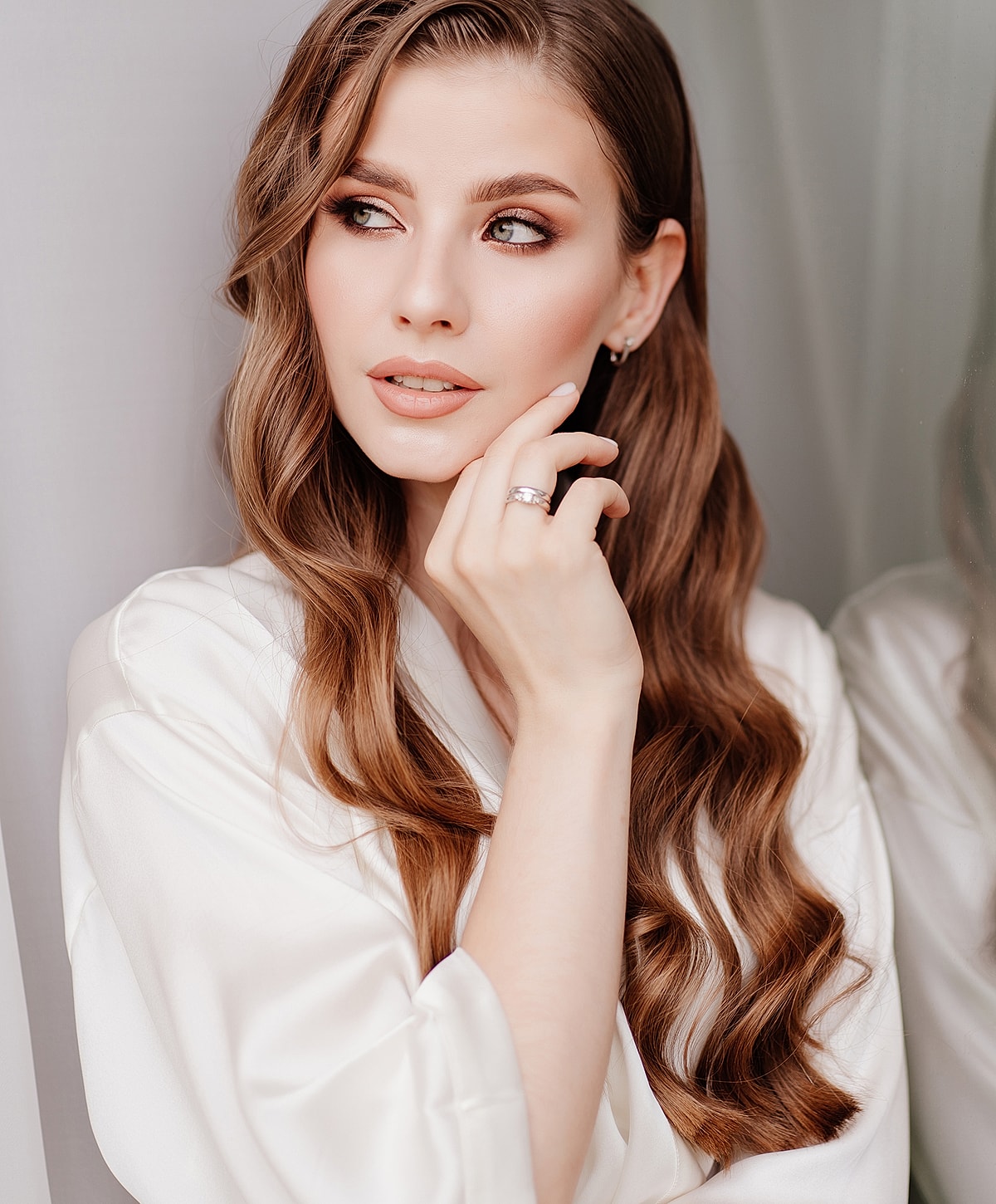 Woman in white robe with wavy hair.