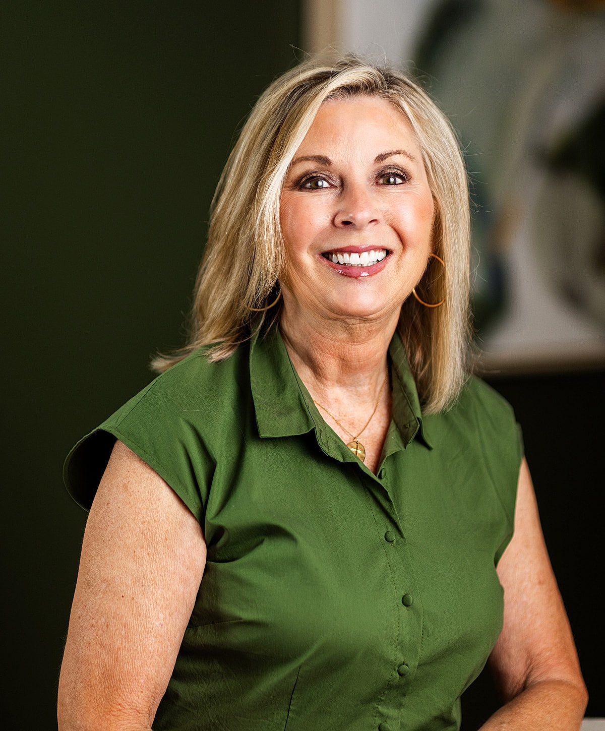 Smiling woman in green blouse portrait.