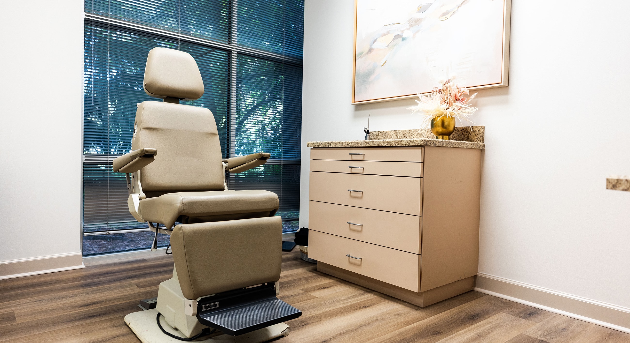 Medical examination room with chair and cabinet.