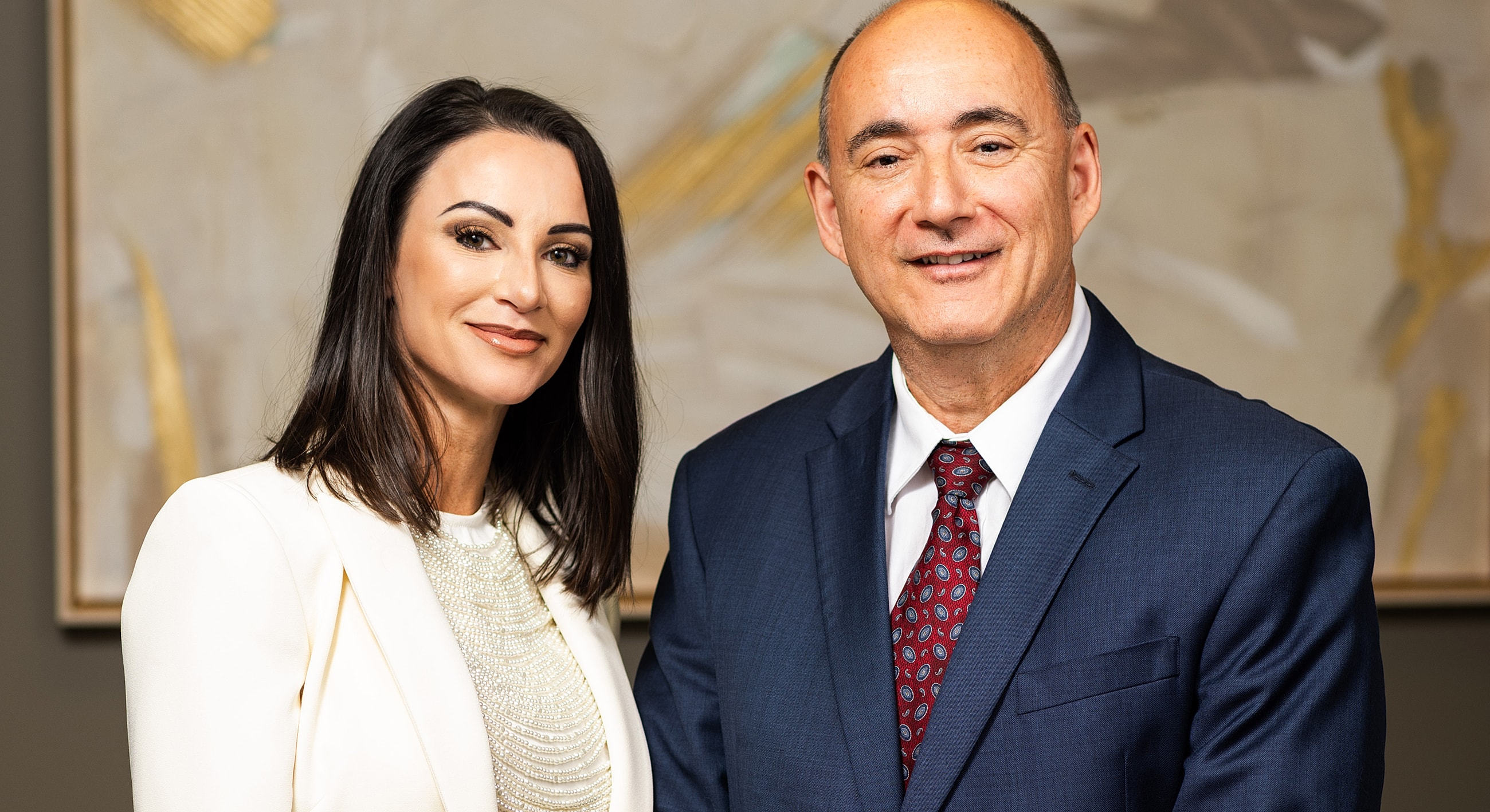 Professional portrait of two smiling individuals.