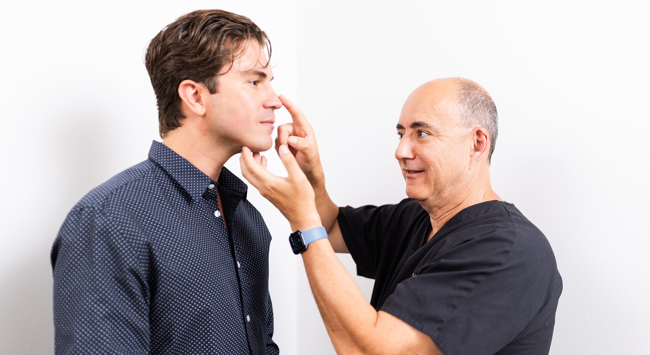 Doctor assessing patient’s facial features.