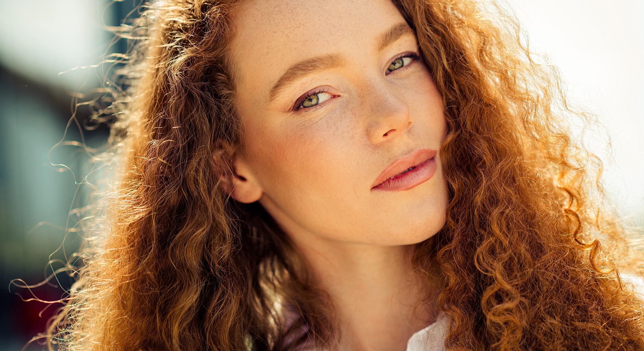 Woman with curly hair and warm sunlight.