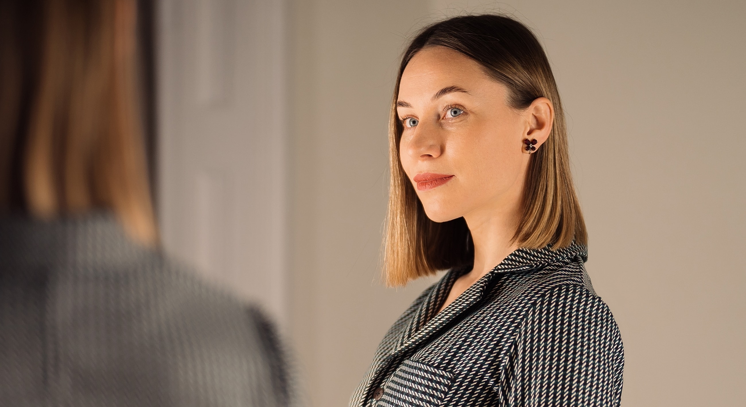 Woman with stylish haircut and elegant attire.