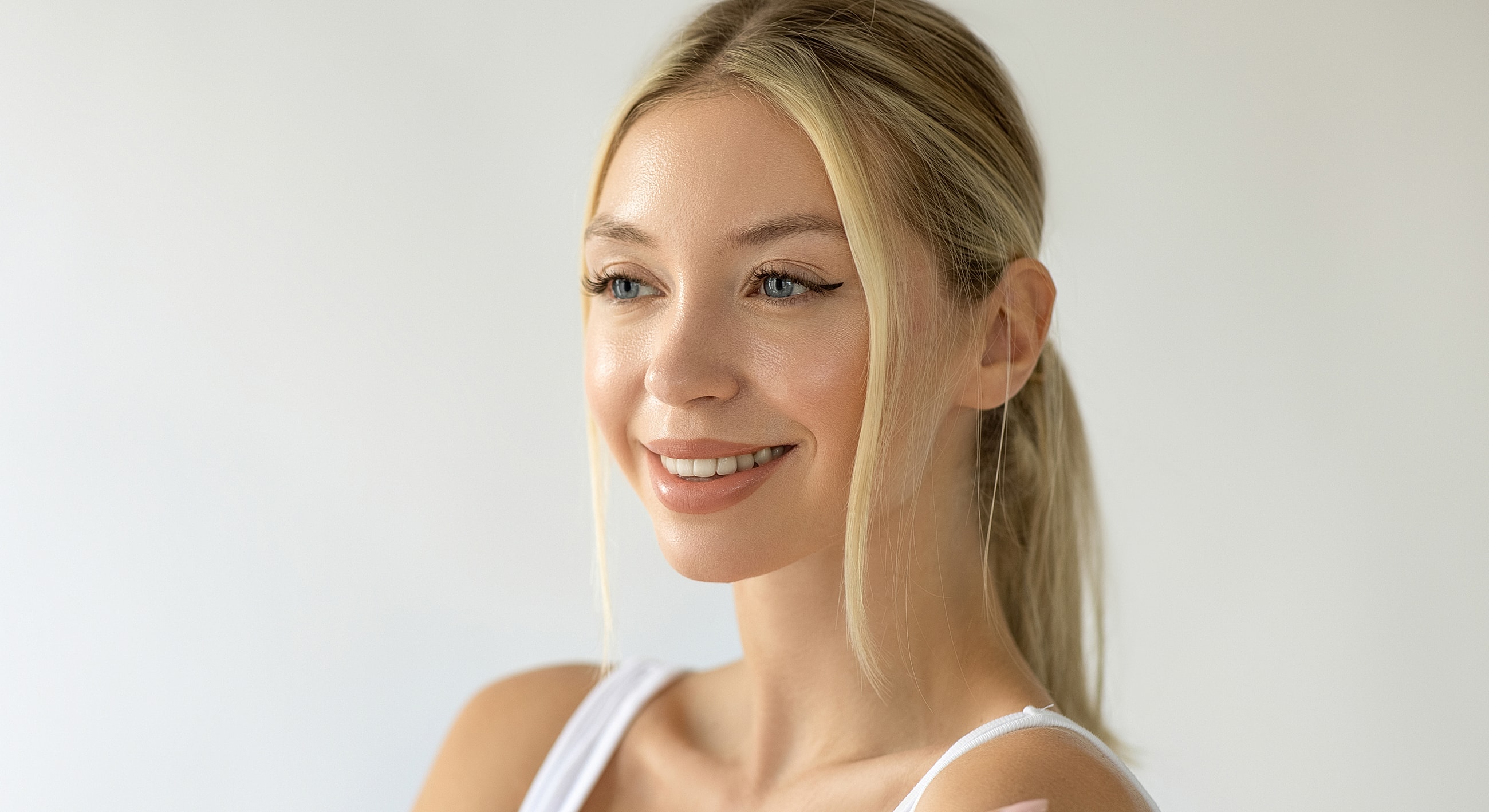 Smiling woman with blonde hair and blue eyes.