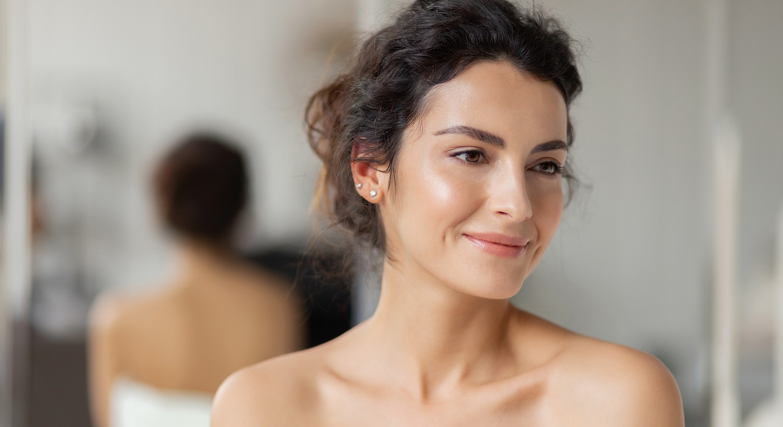 Smiling woman with natural makeup, soft lighting.