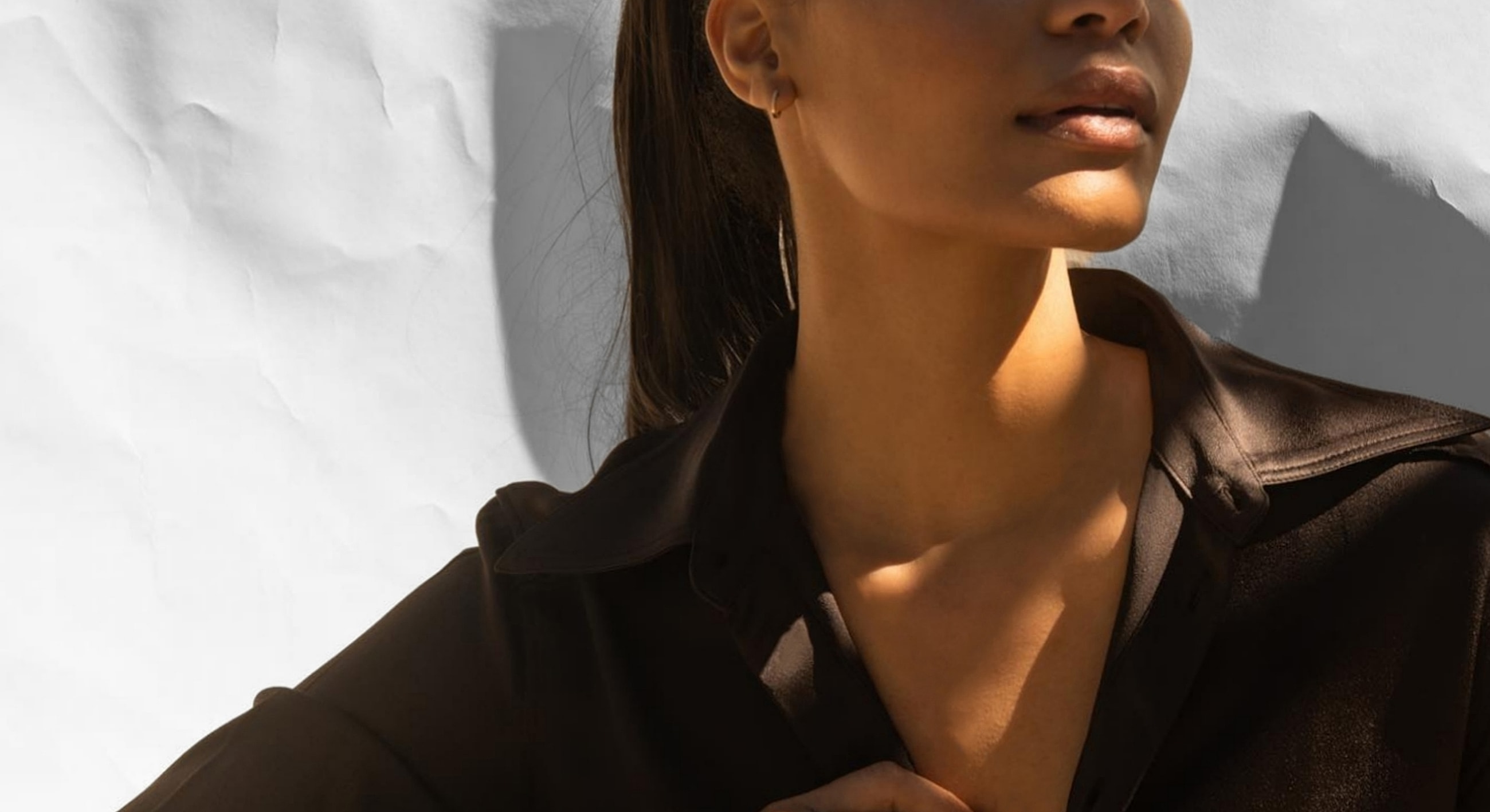 Woman in a black shirt with dramatic lighting.